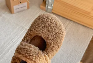 Primo piano della calda consistenza del pile orsetto marrone sulle scarpe Mary Jane.