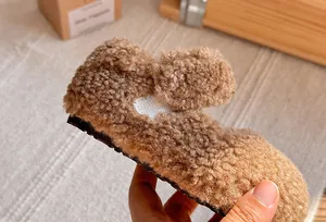 Primo piano di scarpe invernali per bambini in pile marrone con trama morbida e calda