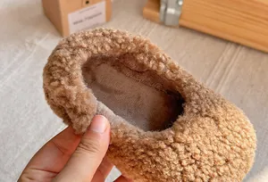 Dettaglio macro della calda fodera in peluche sui mocassini pelosi per bambini stile francese