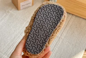 Dettaglio della suola in gomma antiscivolo delle scarpe invernali in peluche per bambini