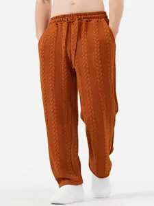Dettaglio dei pantaloni casual da uomo in maglia a trecce arancione con coulisse in vita