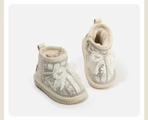 Detailed view of toddler girls' snow boots featuring a pearl-studded bow and glitter