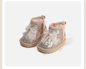 Detailed view of girls' glittery snow boots with pearl bows and plush lining