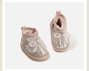 Detail view of toddler girls' pink snow boots with glitter sequins and pearl bow