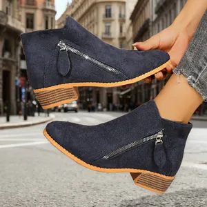 Close-up of navy blue suede ankle boots with chunky heel and stylish side zipper.