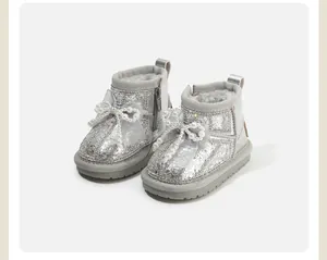 Elegant silver glitter toddler snow boots featuring decorative pearl bows for winter style.