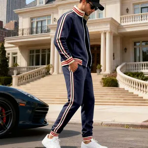 Side view of men's navy blue fleece tracksuit with striped details in luxury setting.