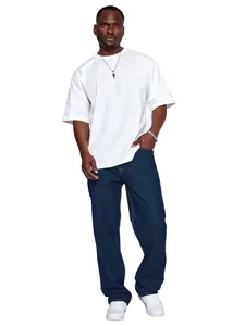 Male model wearing men's loose straight-leg denim jeans in dark blue against white