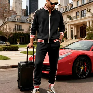 Men's black fleece tracksuit set featuring red and white striped cuffs in a luxury setting