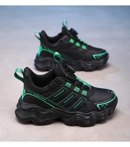 Detail shot of black and green kids' sneakers featuring a modern rotating buckle closure