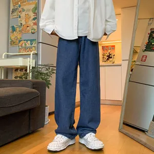 Relaxed fit straight leg blue jeans for men styled with a white shirt and sneakers