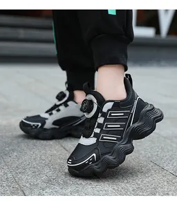 Detailed view of children's sports shoes with rotary buckle on a grey stone pavement.