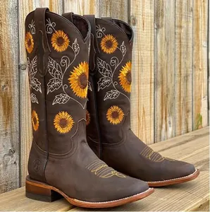 Detail view of dark brown cowboy boots with embroidered yellow sunflowers and square toes