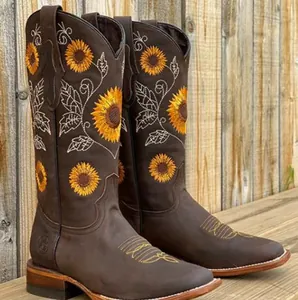 Detail view of vibrant sunflower embroidery on brown leather western cowboy boots