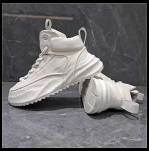 Vista laterale di sneaker alte in pelle bianca con spesse suole platform ondulate