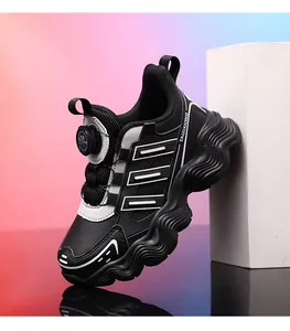 Close-up of black children's sports shoes with rotary button and wavy thick sole.