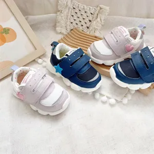 Detail of lightweight baby walking shoes in purple heart and blue star patterns.