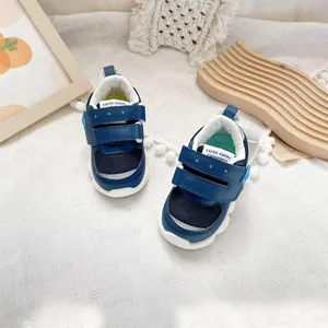 Detail of blue baby walking shoes featuring double Velcro straps and breathable mesh