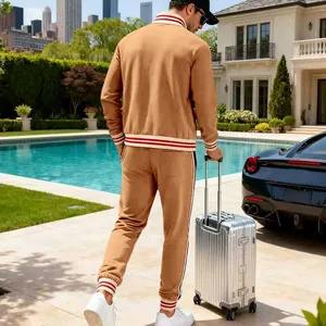 Back view of men's camel fleece tracksuit with striped ribbing in luxury outdoor setting