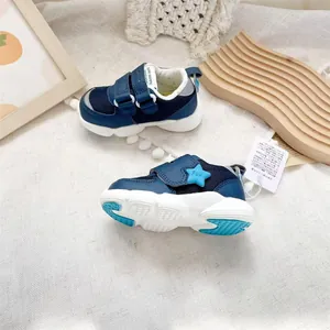 Detail of navy blue baby walking shoes featuring soft mesh and star velcro strap.