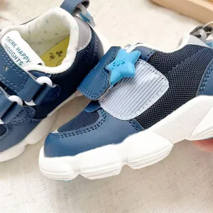 Detail of navy blue toddler sneakers with star-shaped Velcro strap