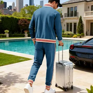 Back view of men's blue fleece tracksuit set with striped ribbing details in luxury setting.