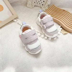 Detailed view of pink and white baby walking shoes with velcro straps and mesh upper.