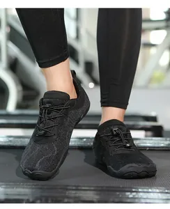 Detailansicht atmungsaktiver schwarzer Barfußschuhe für Fitnesstraining auf Laufband.