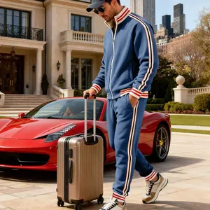 Man in blue heavyweight fleece tracksuit with red and white stripes beside red luxury car