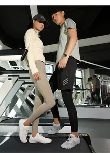 Ein männliches und weibliches Modell tragen Barfuß-Sportschuhe auf Laufbändern im Gym.