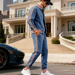 Side view of men's blue fleece tracksuit with striped details in a luxury outdoor setting