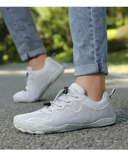 Detailansicht der grauen Barfußschuhe mit breitem Zehenbereich auf einem Außenweg.