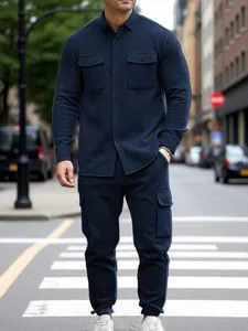 Full body view of a man in a navy blue heavyweight cargo jacket and matching pant set