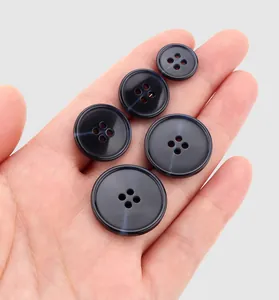 Close-up of premium resin four-hole buttons with elegant marbled texture on a hand