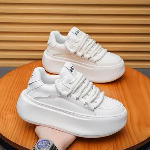 Close-up of white platform chunky sneakers with thick rope laces and soft sole.