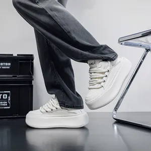 Close-up of stylish white chunky platform sneakers with wide laces on a model
