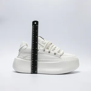 Close-up of white chunky platform sneaker with a ruler measuring the 8cm sole height.