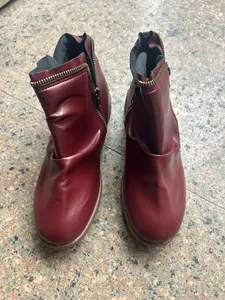 Detailed view of stylish women's burgundy round toe ankle boots with double side zippers
