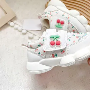 Detailed view of white toddler walking shoes with cute cherry pattern ornament