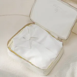 Beige Taslan travel packing cube with folded white shirt inside for luggage organization
