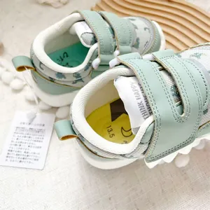 Close-up detail of sage green baby walking shoes with soft soles and dual velcro straps