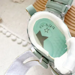 Interior detail of mint green baby walking shoe with breathable lining and 13.5 size