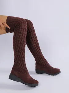 Vista detallada de botas mosqueteras de punto granate con cuña puestas en la modelo