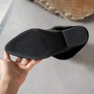 Close-up view of the black non-slip rubber sole on the pointed toe mid-calf boot
