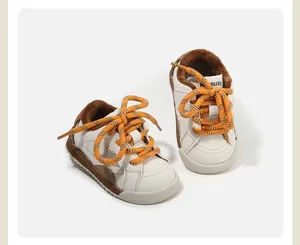 Primer plano de zapatillas blancas para niños con forro de felpa cálido y cordones naranjas