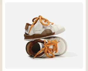 Detalle de primer plano del forro polar cálido y cordones naranjas en zapatillas para niños.