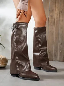 Close-up detail of stylish brown pointed toe gaiter boots with buckle and block heel