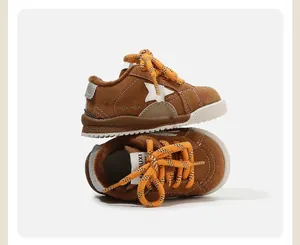 Zapatillas forradas para bebés en color marrón con parche de estrella y cordones naranjas.