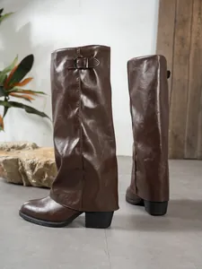 Side view of stylish brown faux leather gaiter boots with a chunky heel and metal buckle
