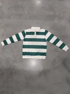Top-down view of a green and white striped long-sleeve polo shirt on a gray floor